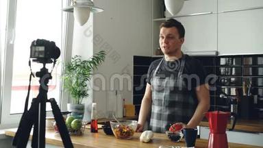 帅哥在家里的厨房里用数码<strong>相机录制</strong>关于健康烹饪的视频食物vlog。 记录和记录